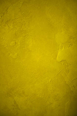 abstract yellow background plaster wall with rough deep vintage grunge background texture design and bright gold color for colorful brochure book cover or elegant old web template background designの写真素材