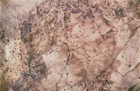 old vintage brown paper background with cracks creased folds and paint stain spatters