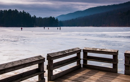Ice skaters on a frozen lake at Cowans Gap State Park, Pennsylvania.の写真素材