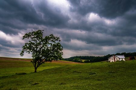 Dark stormy sky over trees and a house in York County, Pennsylvania.の写真素材