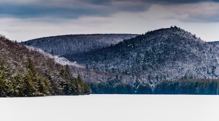 Snow and ice covered mountains surrounding Long Pine Run Reservoir, in Michaux State Forest, Pennsylvania.の写真素材