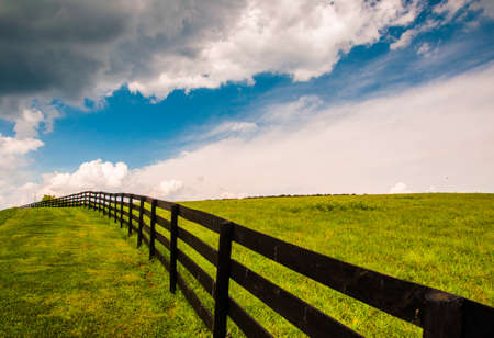 Beautiful summer sky over fence and field in Southern York County, Pennsylvania.の写真素材