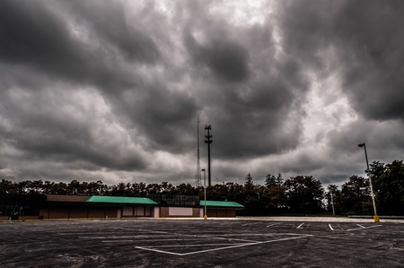 Dark storm clouds over an abandoned shopping center and parking lot.のeditorial素材