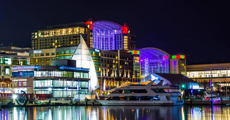 Buildings and a boat on the shore of the Potomac River at night, in National Harbor, Maryland.のeditorial素材