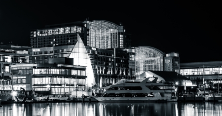 Buildings and a boat on the shore of the Potomac River at night, in National Harbor, Maryland.のeditorial素材