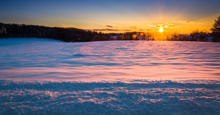 Sunset over a snow covered field in rural York County, Pennsylvania.の写真素材