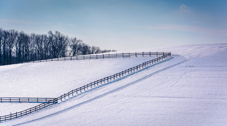 Fences on a snow covered farm field in rural Carroll County, Maryland.の写真素材