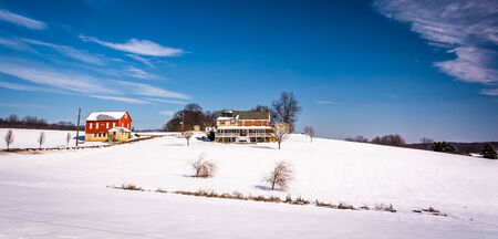 House and barn on snow covered farm fields in rural Carroll County, Maryland.のeditorial素材