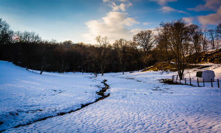 Stream in a snow-covered field in rural Baltimore County, Maryland.の写真素材