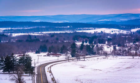 View of road through snow-covered fields and distant mountains, from Longstreet Tower, in Gettysburg, Pennsylvania.の写真素材