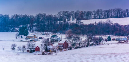 View of snow covered farm fields and houses in rural York County, Pennsylvania.の写真素材