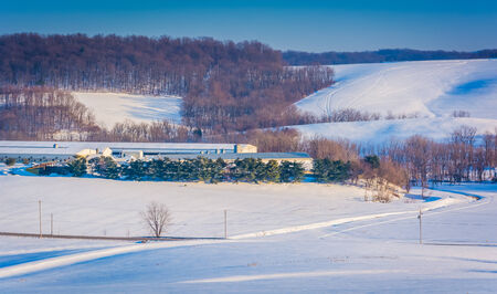 View of snow covered rolling hills and farm fields in rural York County, Pennsylvania.の写真素材