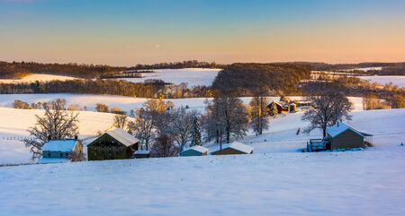 View of snow covered rolling hills and farm fields in rural York County, Pennsylvania.の写真素材