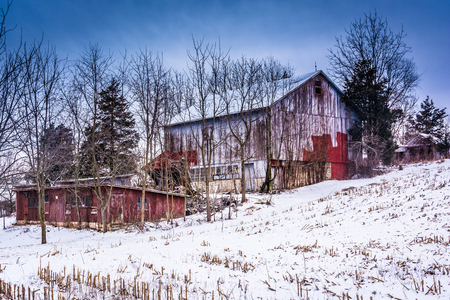 Old barn and a snow covered field in rural York County, Pennsylvania.のeditorial素材