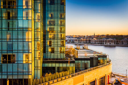 View of the Legg Mason Building and waterfront at sunset, in Baltimore, Maryland.