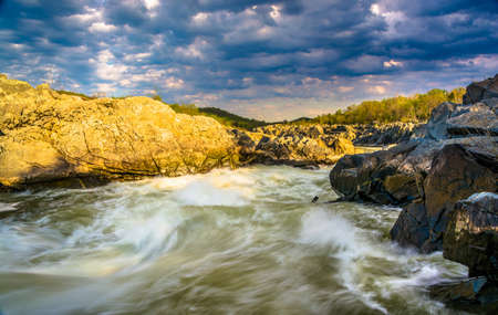 Evening light on rocks and rapids in the Potomac River, at Great Falls Park, Virginia.の写真素材