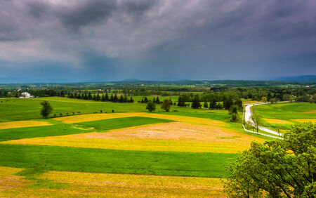 Storm clouds over fields and distant mountains seen from Longstreet Observation Tower in Gettysburg, Pennsylvania.の写真素材