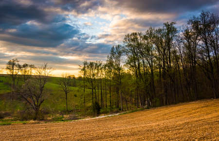 Sunset sky over farm fields and trees in rural York County, Pennsylvania.の写真素材