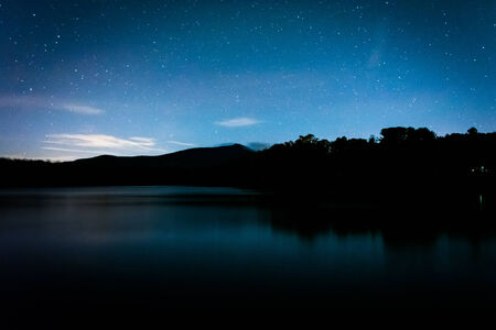 Stars over Julian Price Lake at night, along the Blue Ridge Parkway in North Carolina.の写真素材