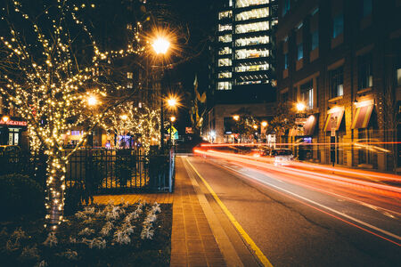 Christmas lights on trees and traffic along a street in Harbor East, Baltimore, Maryland.のeditorial素材