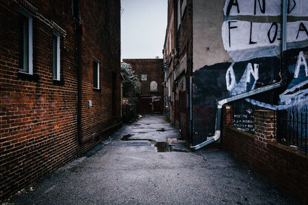Dark alley and old brick buildings in Baltimore, Maryland.のeditorial素材