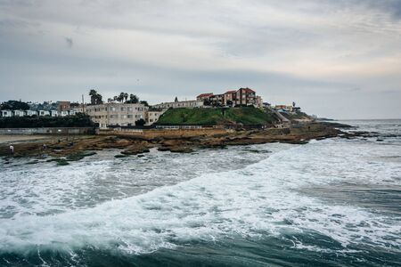 Waves in the Pacific Ocean and view of buildings on the coast in Ocean Beach, California.の写真素材