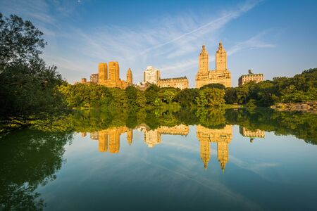 Buildings reflecting in The Lake, at Central Park, in Manhattan, New York.の写真素材