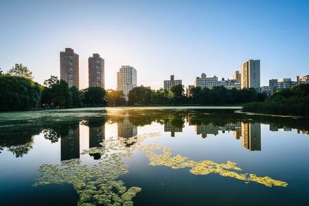Sunrise over buildings and the Harlem Meer, in Manhattan, New York.の写真素材