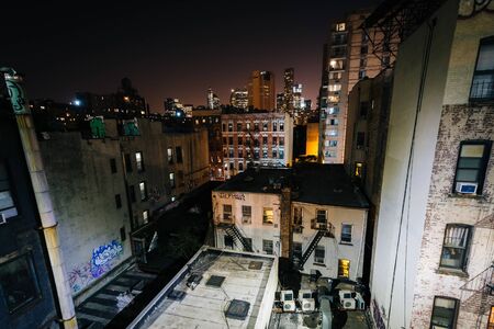 View of buildings in the Lower East Side from the Manhattan Bridge Walkway at night, in Manhattan, New York.のeditorial素材