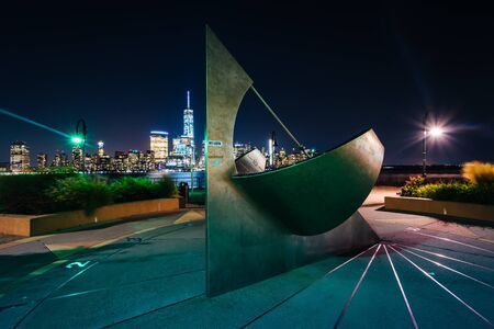 Sundial and view of the Lower Manhattan skyline at night, in Jersey City, New Jersey.のeditorial素材
