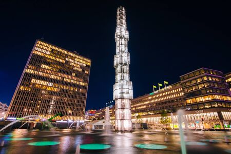 Glass obelisk and fountains in the traffic circle at night, at Sergels torg, in Norrmalm, Stockholm, Sweden.のeditorial素材