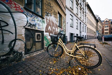 Parked bicycle and graffiti on a building in Copenhagen, Denmark.のeditorial素材