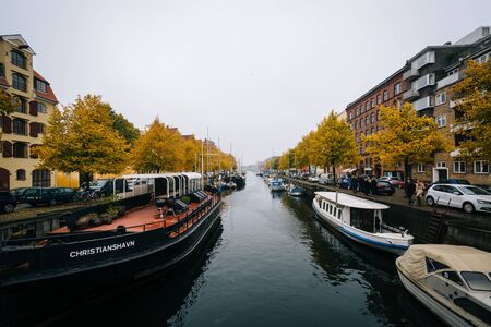 Autumn color and boats along the Christianshavn Canal, in Christianshavn, Copenhagen, Denmark.