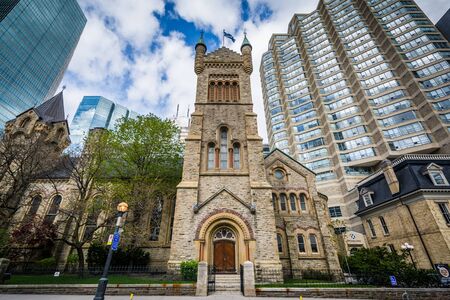 St Andrew's Presbyterian Church and modern buildings along Simcoe Street, in downtown Toronto,...