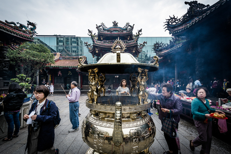 The burning of incense sticks, at Longshan Temple in the Wanhua District of Taipei, Taiwan.のeditorial素材