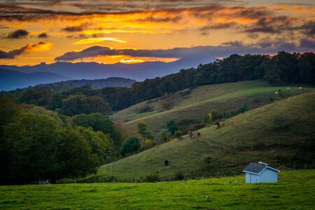 Sunset over rolling hills and farm fields at Moses Cone Park on the Blue Ridge Parkway in North Carolina.の写真素材