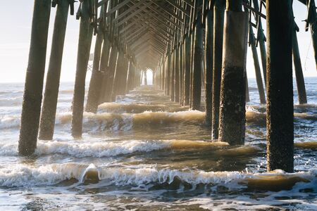Waves under the pier, in Folly Beach, South Carolina.の写真素材