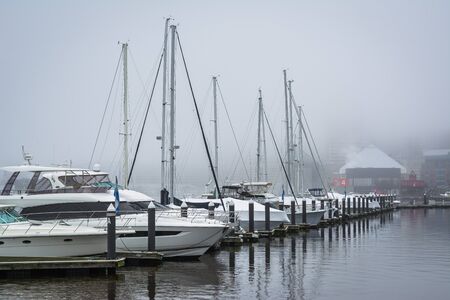 A marina in fog, at the Inner Harbor, in Baltimore, Maryland.の写真素材