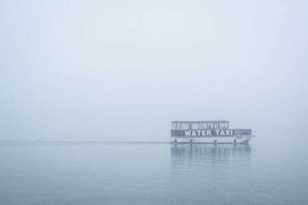 A water taxi in fog, in Fells Point, Baltimore, Maryland.の写真素材