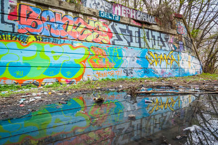 Graffiti reflecting in a puddle at Graffiti Pier in Philadelphia, Pennsylvania.の写真素材