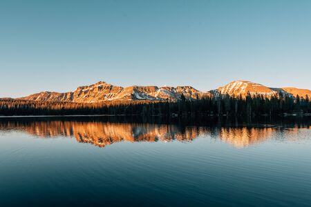 Snowy mountains reflecting in Mirror Lake, in the Uinta Mountains, Utahの写真素材