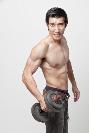 muscle man posing with the dumbbellの写真素材