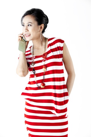 Woman in red stripes dress on the phone isolated on whiteの写真素材