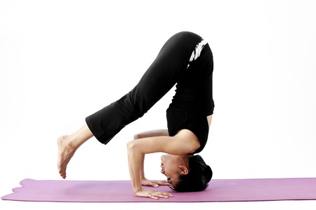 Asian female practising yoga on matの写真素材