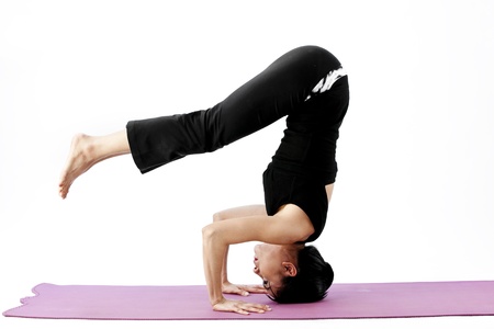 Asian female practising yoga on matの写真素材