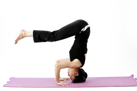 Asian female practising yoga on matの写真素材
