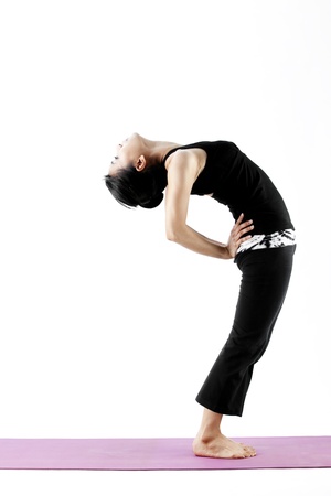 Asian female practising yoga while bending backwardsの写真素材
