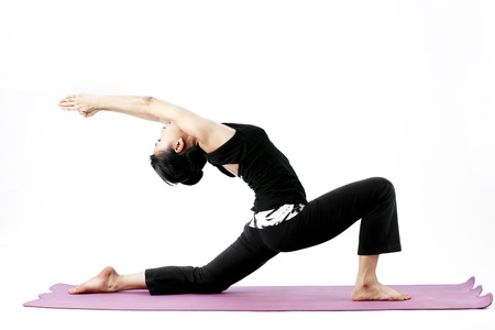 Asian female practising yoga on matの写真素材