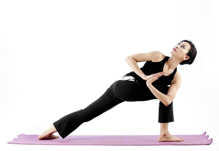 Asian female practising yoga on matの写真素材