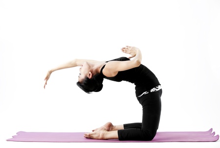 Asian female practising yoga by bending backwards